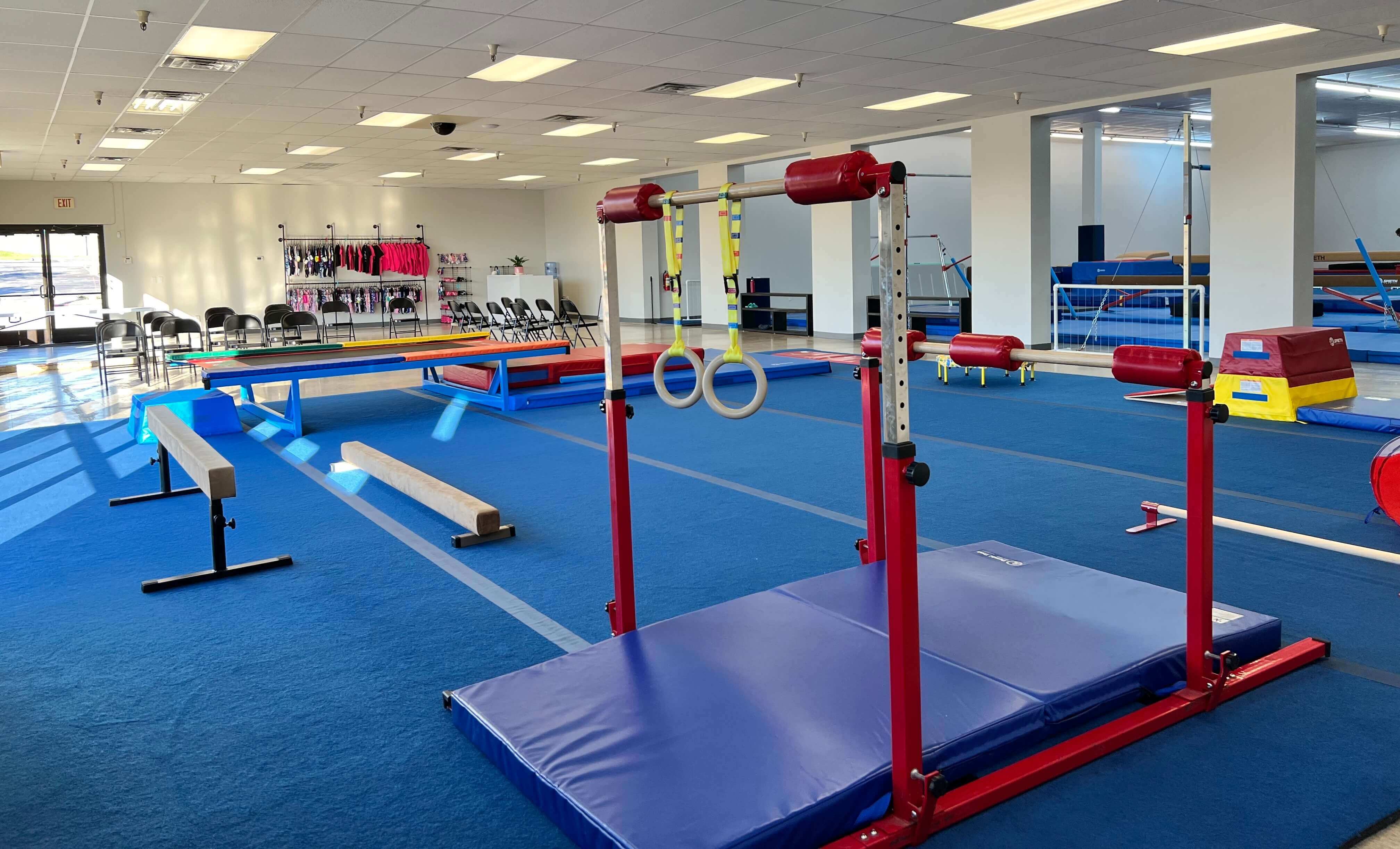 The gym at Texas Twisters: bars, rings, beams, and a blue floor